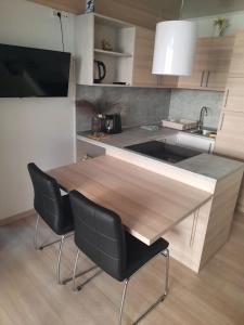 a kitchen with a wooden table and two chairs at Sweet house Pakoštane in Pakoštane +10 photos