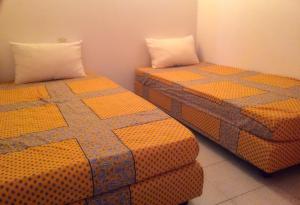 - deux lits assis l'un à côté de l'autre dans une pièce dans l'établissement Savanna Beach, au Cap d'Agde