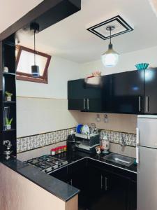 a kitchen with black cabinets and a black counter top at Appartement au centre de TIZNIT in Tiznit