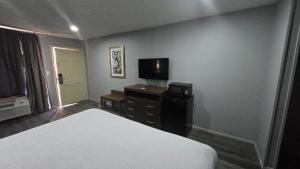 a hotel room with a bed and a television at OYO Jeffersonian Motor Inn in Prentiss +19 photos