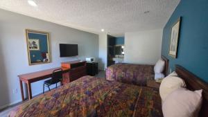 a hotel room with two beds and a desk with a computer at OYO Jeffersonian Motor Inn in Prentiss