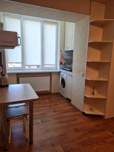 a kitchen with a table and a kitchen with windows at Подобово Своя квартира район ЮЖД in Kharkiv