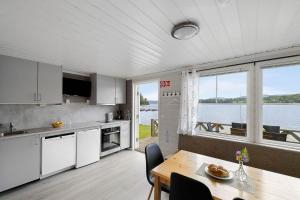una cucina con tavolo e vista sull'acqua di First Camp Norsjø Telemark a Akkerhaugen