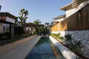 a swimming pool in front of a house at Pousada Pono Village in Juquei