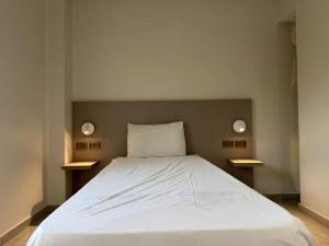 ein Schlafzimmer mit einem weißen Bett mit zwei Leuchten in der Unterkunft Viaje Hotel Downtown Cairo in Kairo