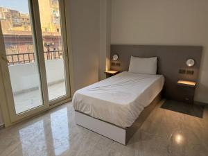 een slaapkamer met een bed en een groot raam bij Viaje Hotel Downtown Cairo in Caïro