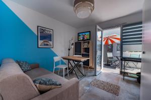 ein Wohnzimmer mit Sofa und Tisch in der Unterkunft Le Rayon de Soleil in Saint-Georges-de-Didonne