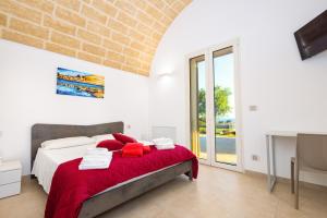 Un dormitorio con una cama con una manta roja. en Villa Falcone - Luxury Pool Sea View, en Lido Marini 44 fotos más