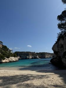 a beach with rocks and the ocean in the background at Apartamento 313 Castell Sol CB in Arenal d'en Castell
