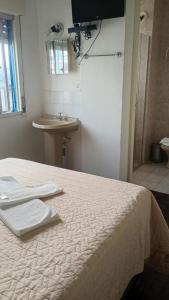 a bedroom with a bed and a sink and a sink at Hotel Paraiso in Santa Maria