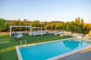 Un patio trasero con piscina con cenador y sillas. en Villa Falcone - Luxury Pool Sea View, en Lido Marini