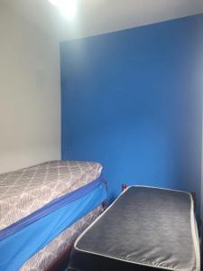 モンガグァーにあるEPK House Mongaguáの青い壁の部屋にベッドが2つある +44枚の写真