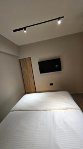 a bedroom with a white bed with a flat screen tv at פאטיו אילת in Eilat