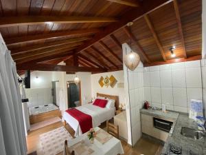 a bedroom with a bed and a tub in a room at Chalés Conforto Mineiro in Gonçalves