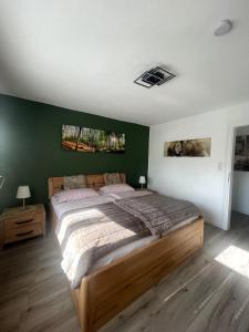 a bedroom with a large bed and a green wall at Eifeltraum Mendig, 3 Sterne, Ferienwohnung in Mendig