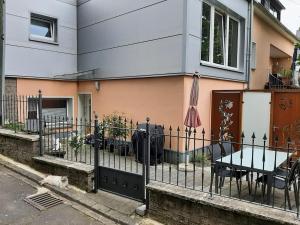 a fence in front of a house with a table and an umbrella at Eifeltraum Mendig, 3 Sterne, Ferienwohnung in Mendig