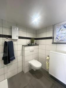 a white bathroom with a toilet and a window at Eifeltraum Mendig, 3 Sterne, Ferienwohnung in Mendig +29 photos