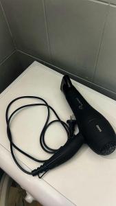 ein schwarzer Haartrockner auf einer Theke in der Unterkunft Квартира на Казахстан 72 in Öskemen + 3 Fotos