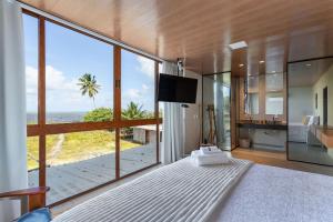 een slaapkamer met een bed en uitzicht op de oceaan bij Piscina e serviço incluído na Rota dos Milagres in Tatuamunha