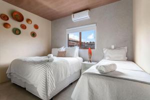 een slaapkamer met twee bedden en een raam bij Piscina e serviço incluído na Rota dos Milagres in Tatuamunha