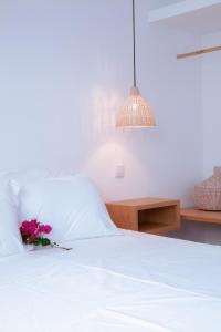 a bedroom with a white bed with a flower on it at Mar-Ria 1 in Fuzeta +10 photos