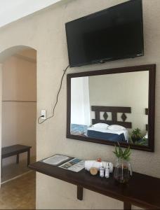 a mirror on a wall with a bed in a room at Hotel y Hostal Casa Don Alfonso in Valladolid +22 photos
