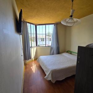 a bedroom with a bed and a large window at Resimed in Antofagasta