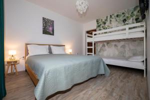 a bedroom with a bed and two bunk beds at In Varful Dealului in Izvoarele