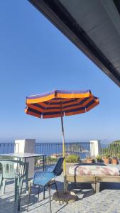 a patio with an umbrella and a table and chairs at Casa Pesce Rooms Rent in Ischia