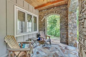 eine Terrasse mit 2 Stühlen und einer Steinmauer in der Unterkunft The Retreat at Wildwood - Hot Tub Theater & Deck in Wildwood