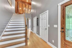 eine Treppe in einem Haus mit weißen Wänden und Holzböden in der Unterkunft The Retreat at Wildwood - Hot Tub Theater & Deck in Wildwood