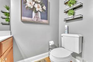 ein Bad mit einem WC und einem Wandgemälde in der Unterkunft The Retreat at Wildwood - Hot Tub Theater & Deck in Wildwood