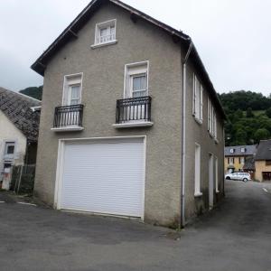 aige brick house with a white garage at Appartement Les Iris in Luz-Saint-Sauveur