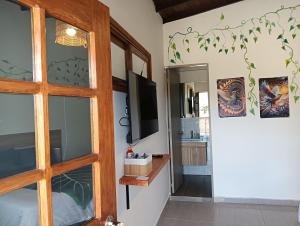 a room with a sliding door and a television at HOSTERIA TERMAL VIVE PARADISE MEDELLIN Only Adult in Medellín