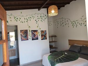 a bedroom with paintings on the wall and a bed at HOSTERIA TERMAL VIVE PARADISE MEDELLIN Only Adult in Medellín