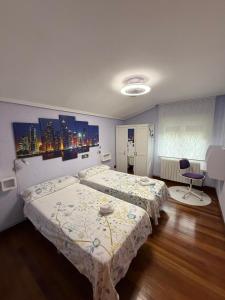 a bedroom with two beds and a table in it at Estancia Edurne in Mungia