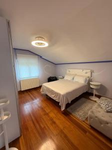 a bedroom with a bed and a wooden floor at Estancia Edurne in Mungia