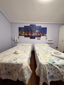 two twin beds in a room with a city at Estancia Edurne in Mungia