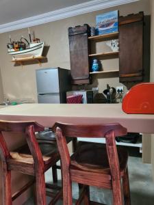 a kitchen with a table and some chairs and a counter at Nawi Unit 2 in Potchefstroom +3 photos