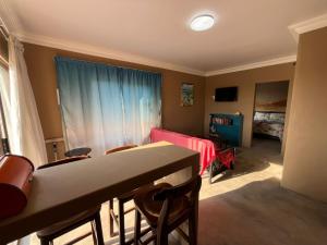 a room with a table and chairs and a bedroom at Nawi Unit 2 in Potchefstroom