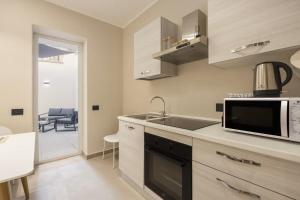 una cocina con fregadero y microondas en Lolli Boutique & SPA Mondello, en Palermo