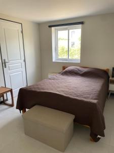 a bedroom with a bed and a window at L'étable de Keriven in La Chapelle-Neuve