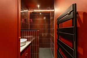 a red bathroom with a sink and a shower at Moulin des reves - Suite Cabaret avec Balneo au coeur de Martigues in Martigues +17 photos