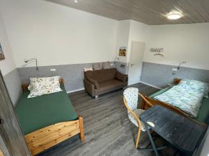 a small room with a bed and a couch at Kaminstube Hof Friebe in Reken