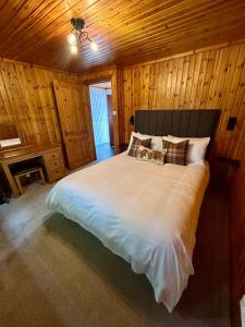 a bedroom with a large bed in a wooden room at Craiglea Cottage in Fort William