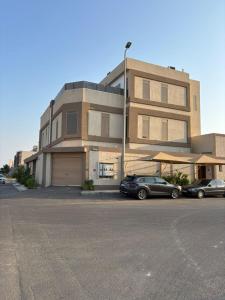 two cars parked in a parking lot in front of a building at شقه مفروشه مميزه 3 in Obhor