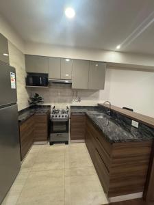a kitchen with a sink and a stove in it at Depar 1 Dormitorio B in Cochabamba
