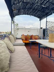 a patio with a couch and tables on a roof at Casa del Sol Marrakech in Marrakech