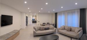 a living room with couches and a flat screen tv at Villa Mare Luna & Villa Mariposa - Dream Luxury Summer Residences by the Aegean Sea in Marmaris