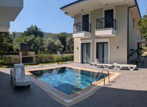 a swimming pool in front of a house at Villa Mare Luna & Villa Mariposa - Dream Luxury Summer Residences by the Aegean Sea in Marmaris